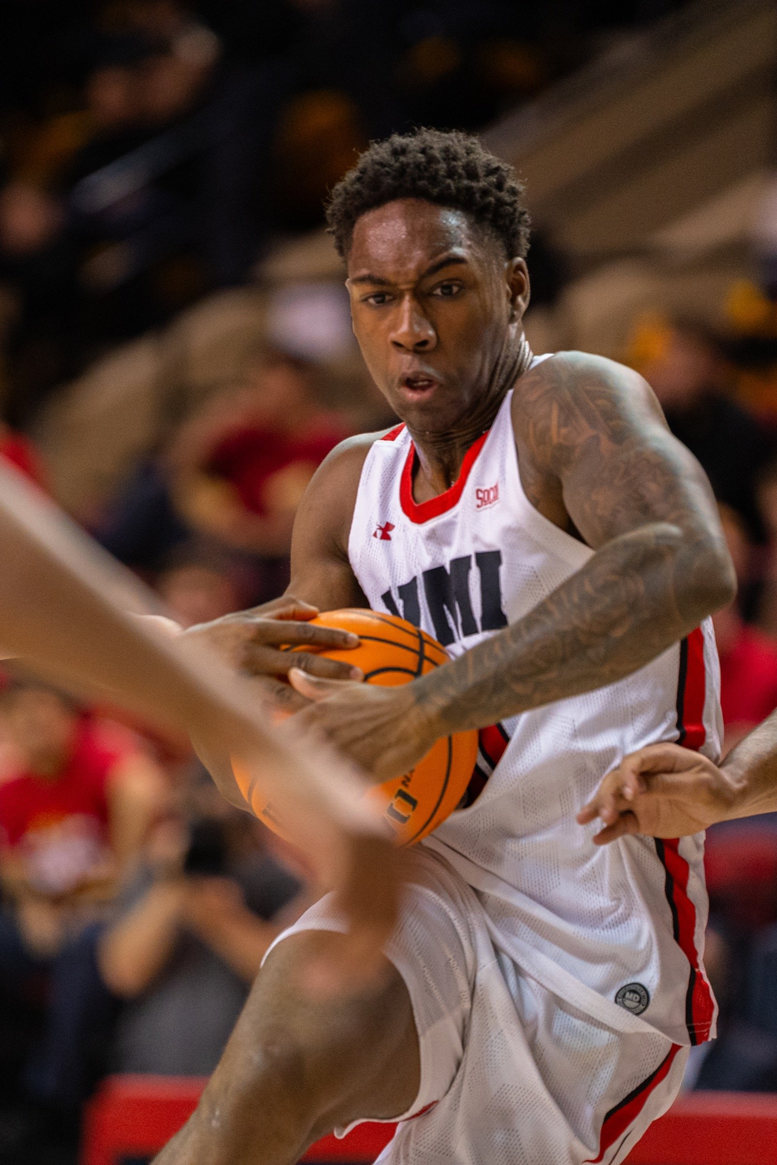 Basketball player driving with the ball through defenders