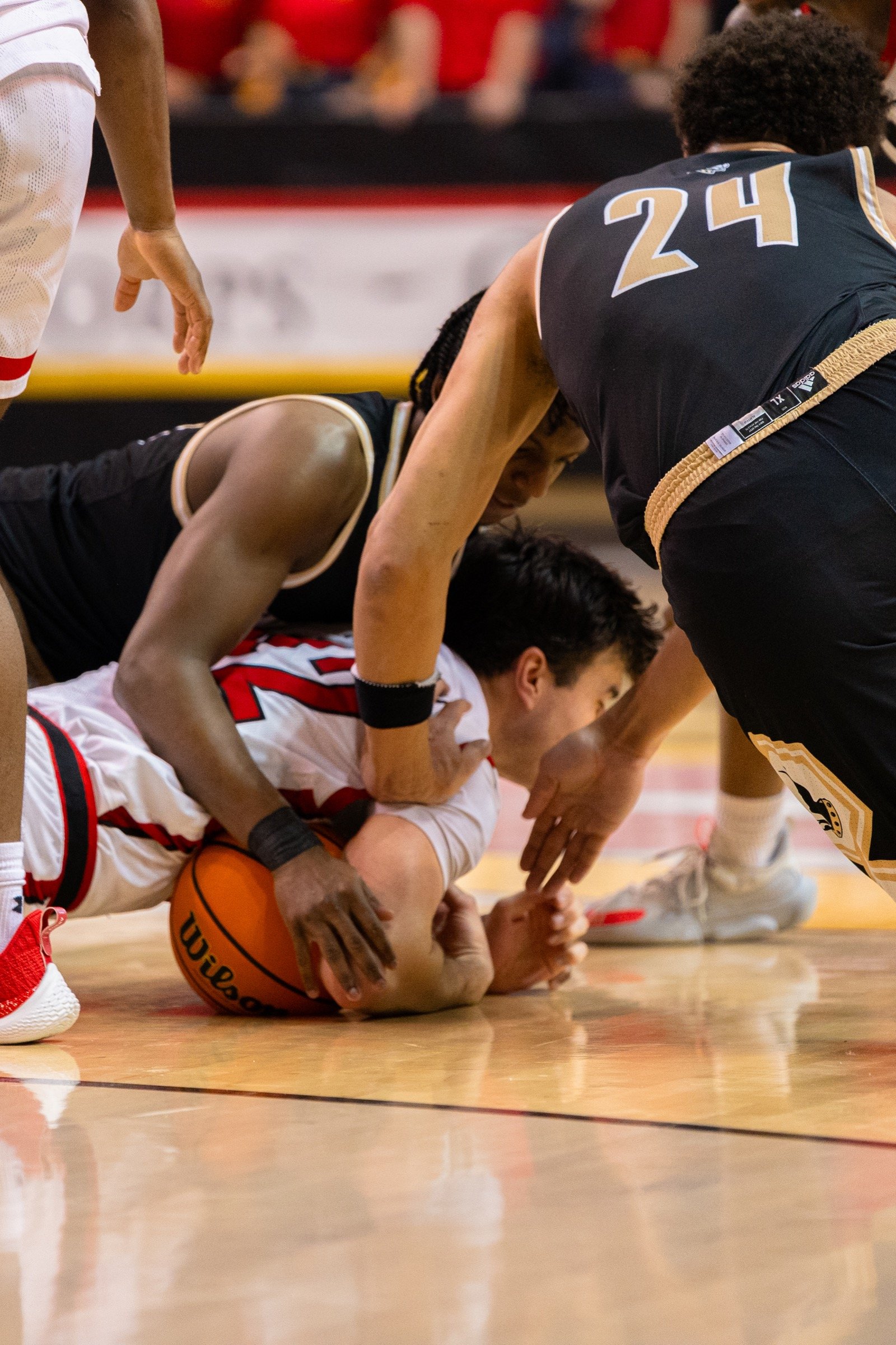 Basketball players fighting for a loose ball on the court