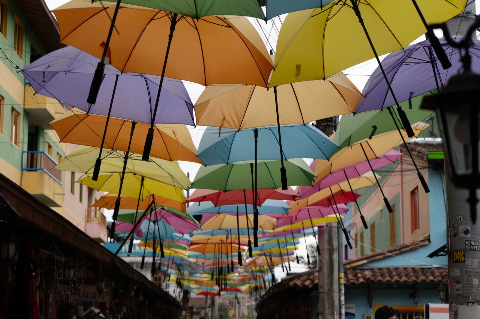 Colorful umbrellas hanging above a narrow pedestrian street