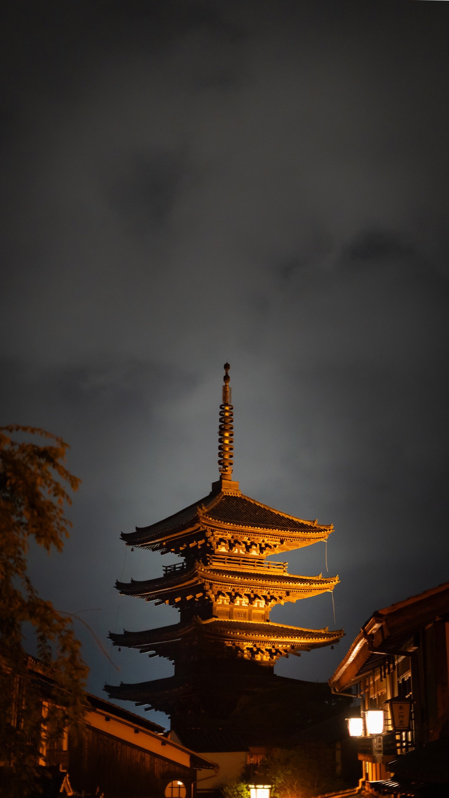 Illuminated pagoda rising into a dark night sky
