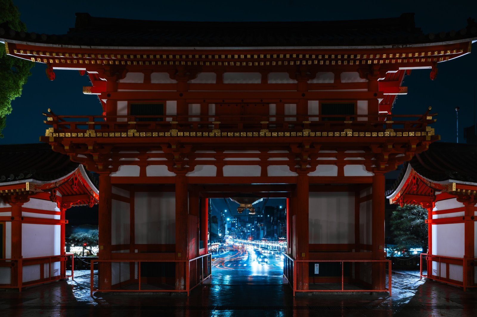 Illuminated temple gate framing a city street at night