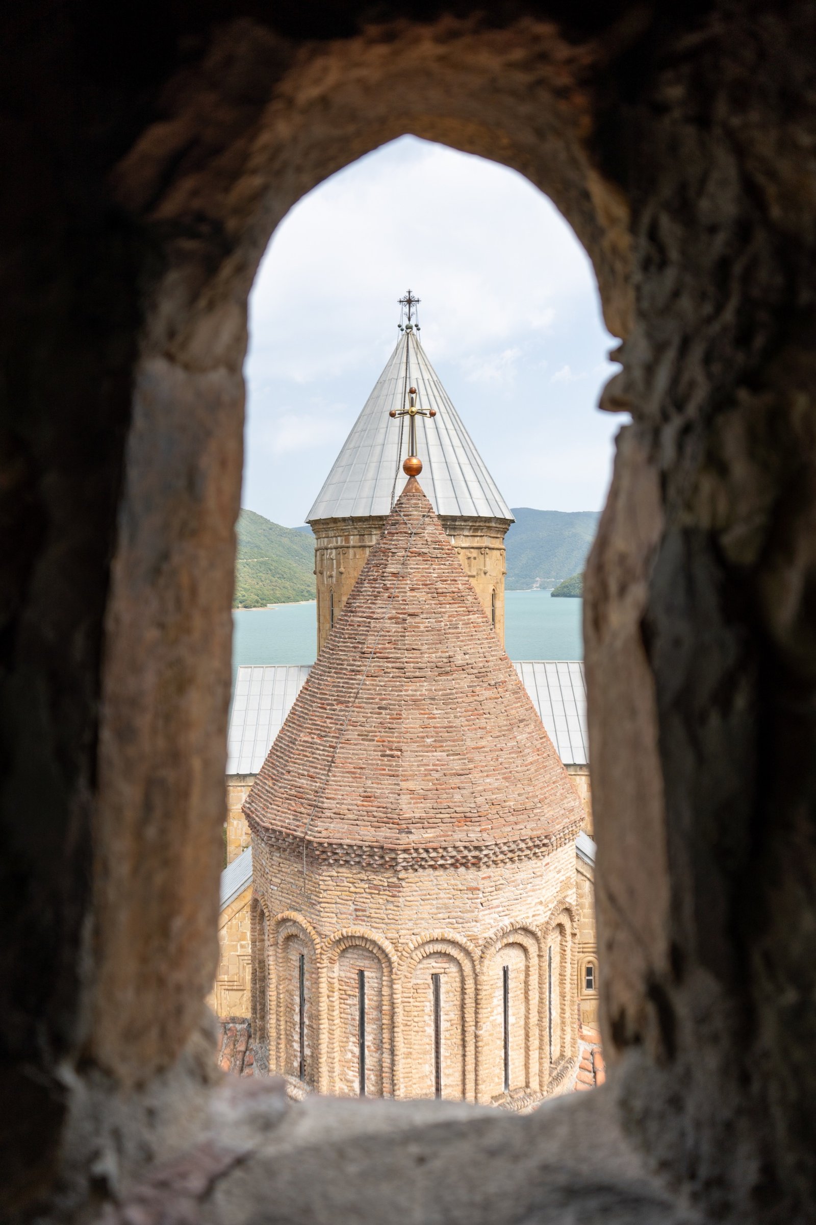 Stone arch framing a tower and coastline beyond