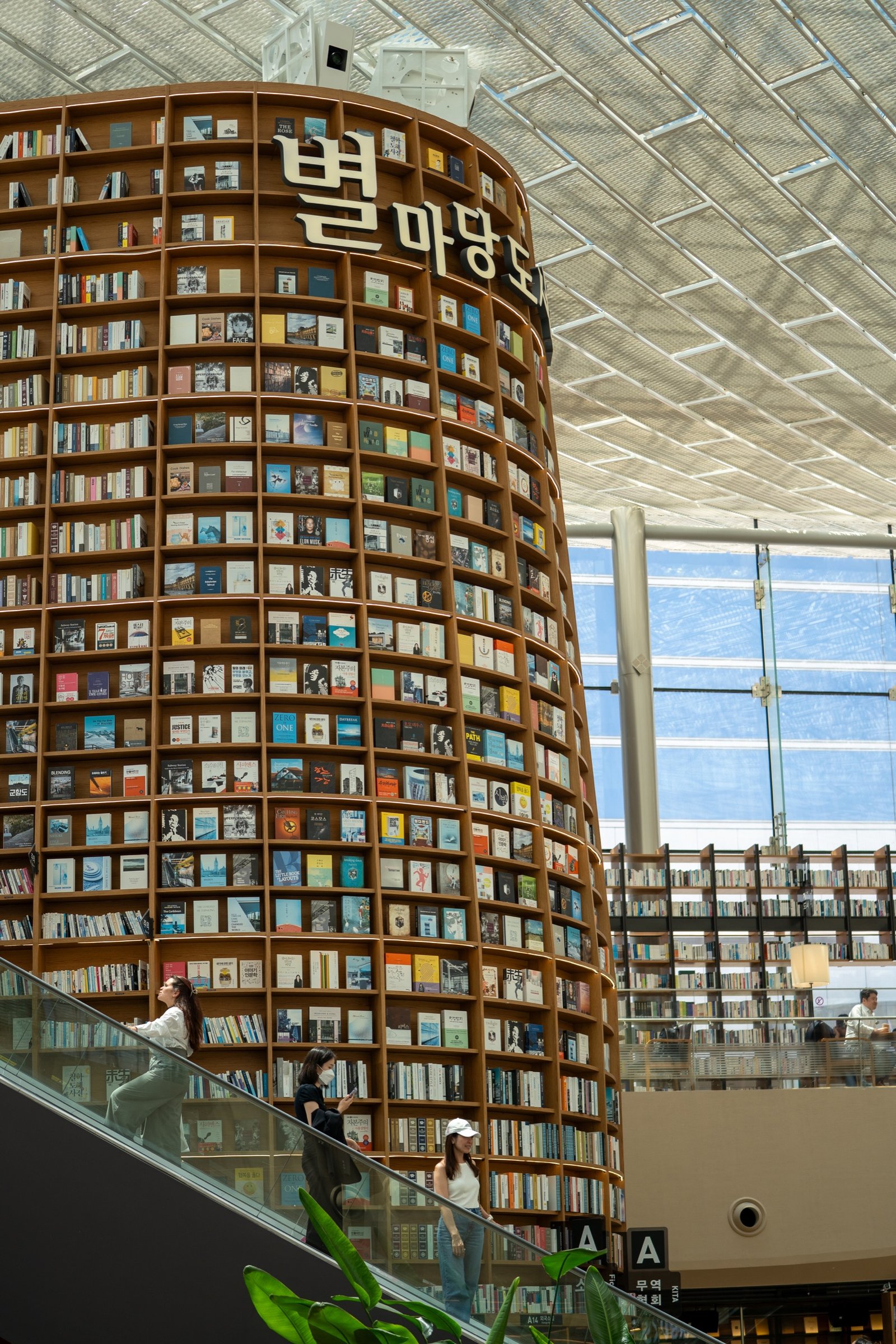 Towering circular bookstore interior with escalators and natural light